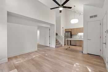 Large living area with ceiling fan and wooden flooring